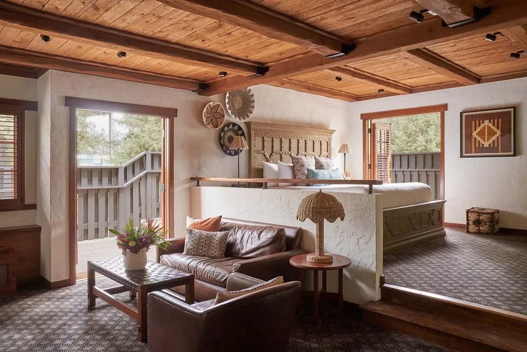 Representative hotel space: A rustic lounge with leather seating, a wooden ceiling, and an adjoining sleeping area.