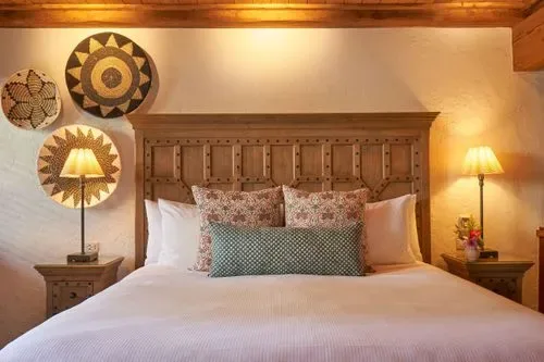 Representative hotel space: A bedroom with a large bed and patterned wall decorations.