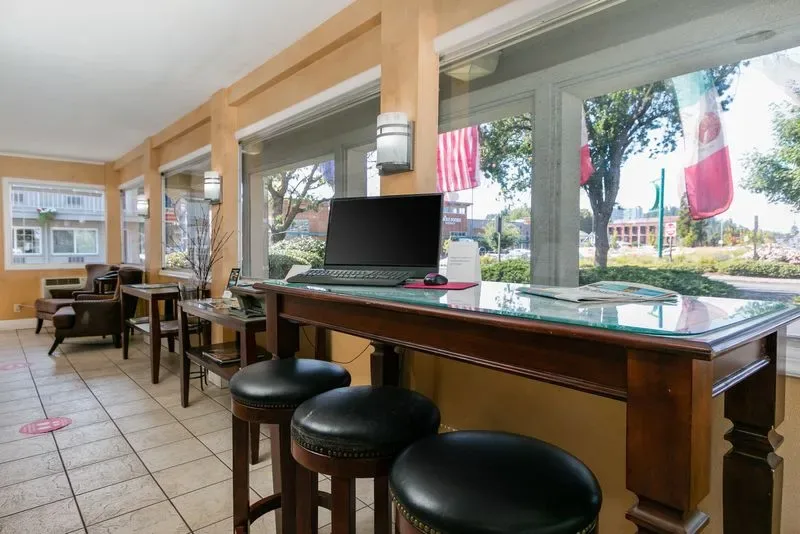 Representative hotel space: A window-side counter with stools and a laptop overlooks the street.