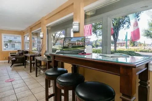 Representative hotel space: A hotel breakfast counter with stools and tables sits beside large windows.