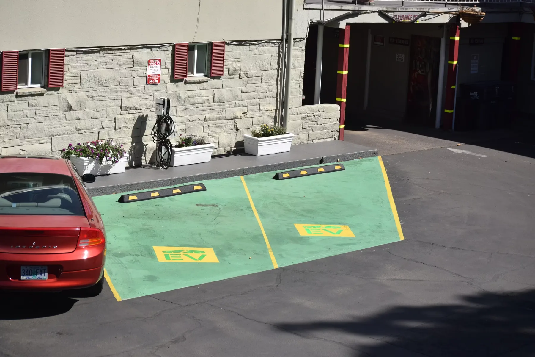 Representative hotel space: A hotel parking area with green-marked spaces beside a stone exterior wall.