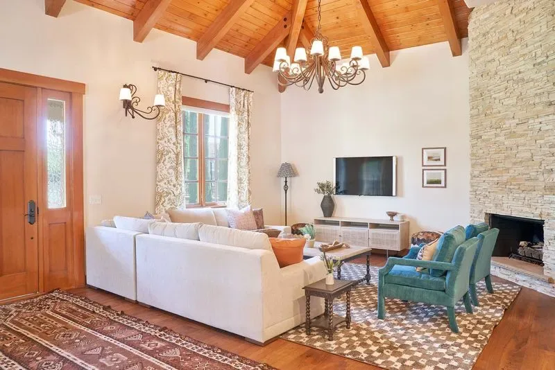 Representative hotel space: Living room with seating, a fireplace, and a vaulted wooden ceiling.