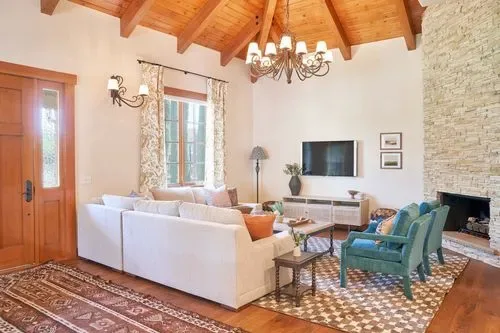Representative hotel space: Living room with seating, a television, and a stone fireplace.
