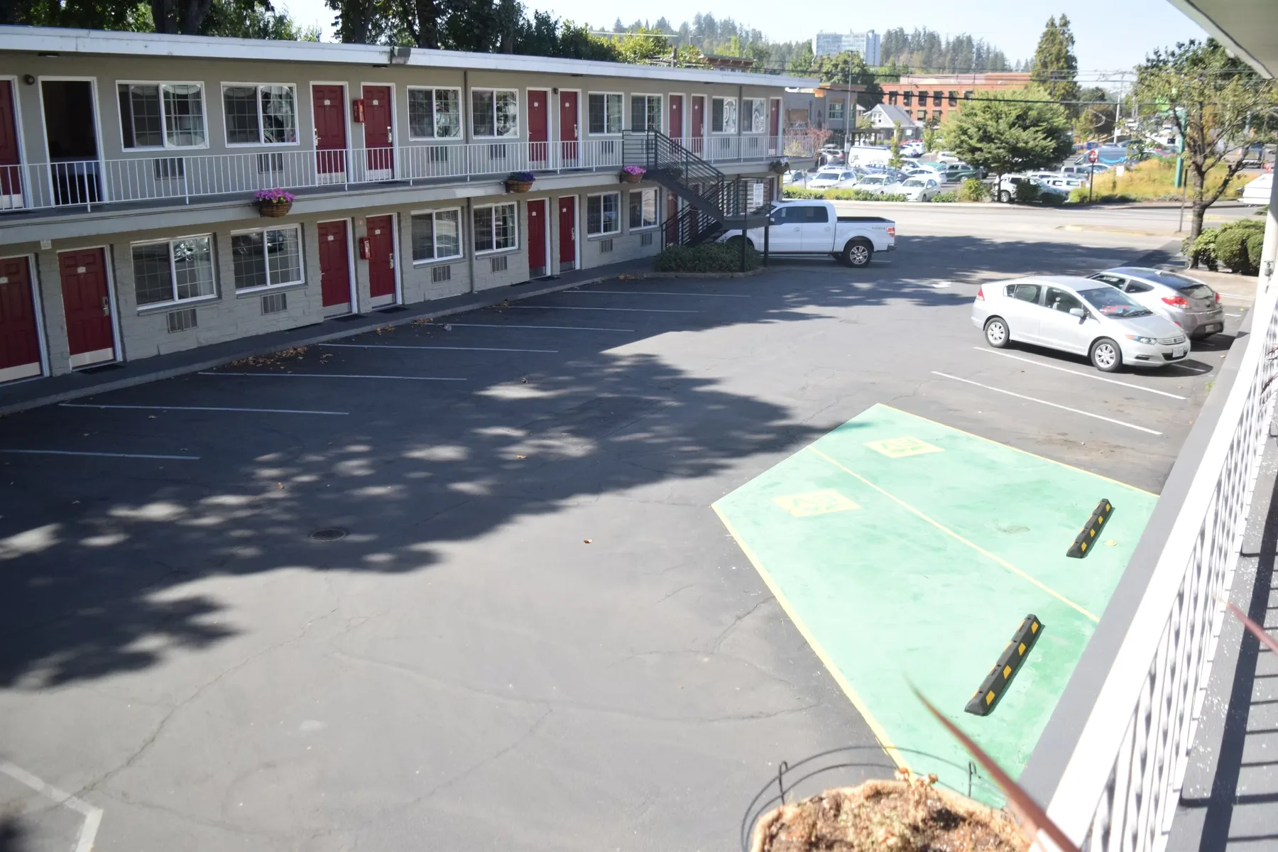 Representative hotel space: A motel building overlooks a parking lot with several parked cars.