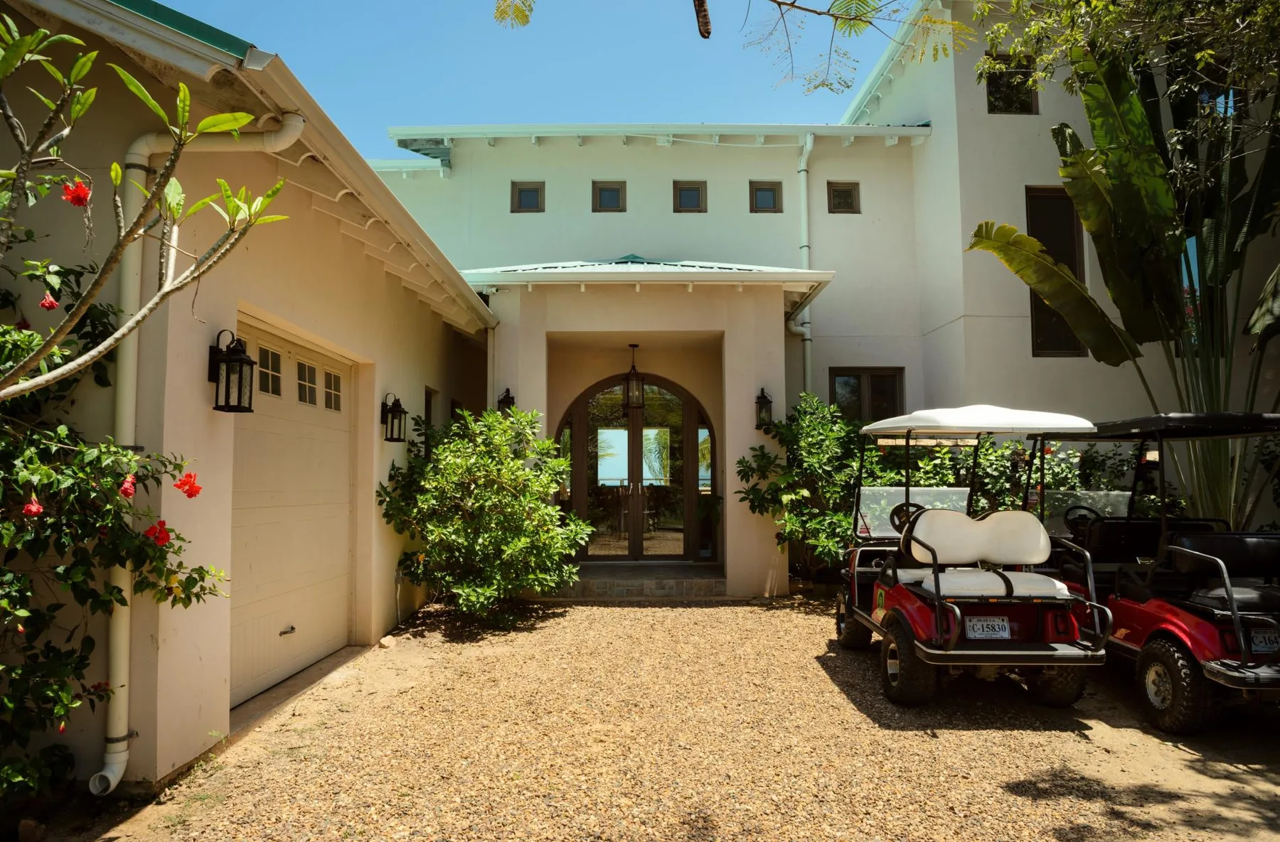 A courtyard entrance with arched glass doors and parked golf carts.