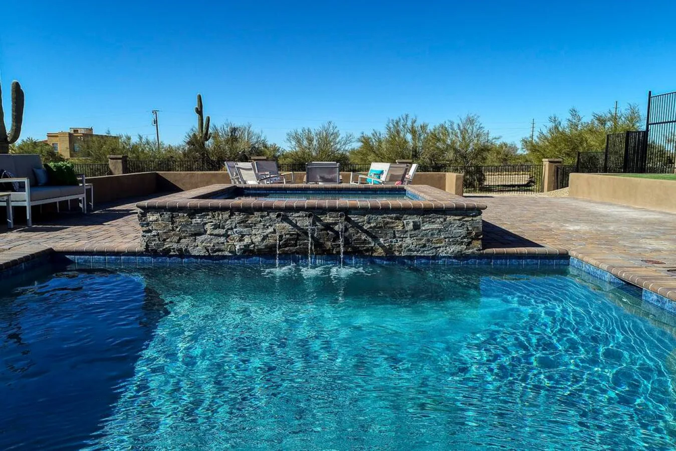 An outdoor swimming pool with lounge seating on the surrounding patio.