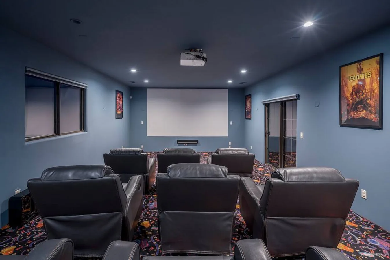 A home theater with rows of seating facing a projection screen.