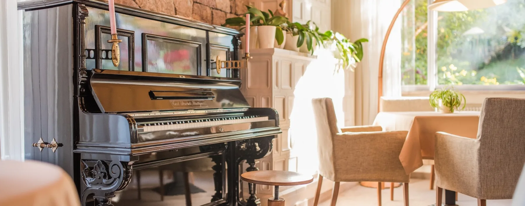Espacio representativo del hotel: Un piano y asientos ocupan una sala luminosa junto a una ventana grande.