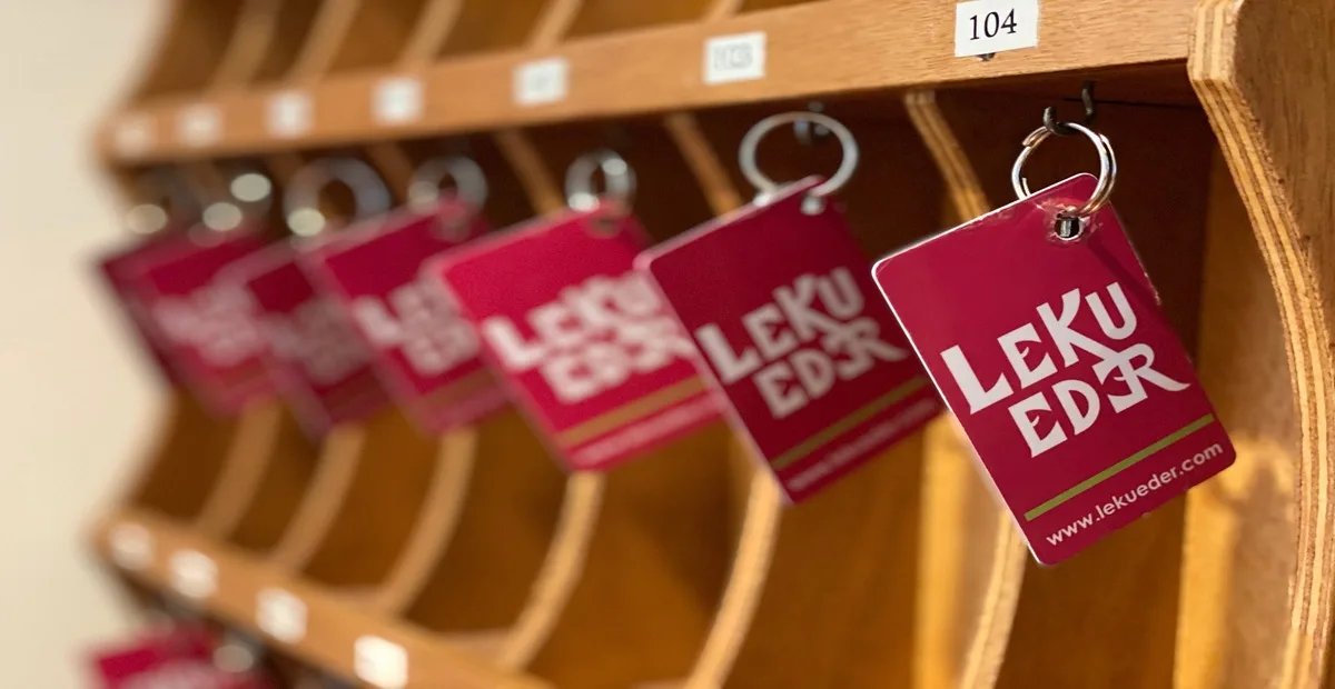 Representative hotel space: A wooden key rack holds several red room key tags, including one marked 104.