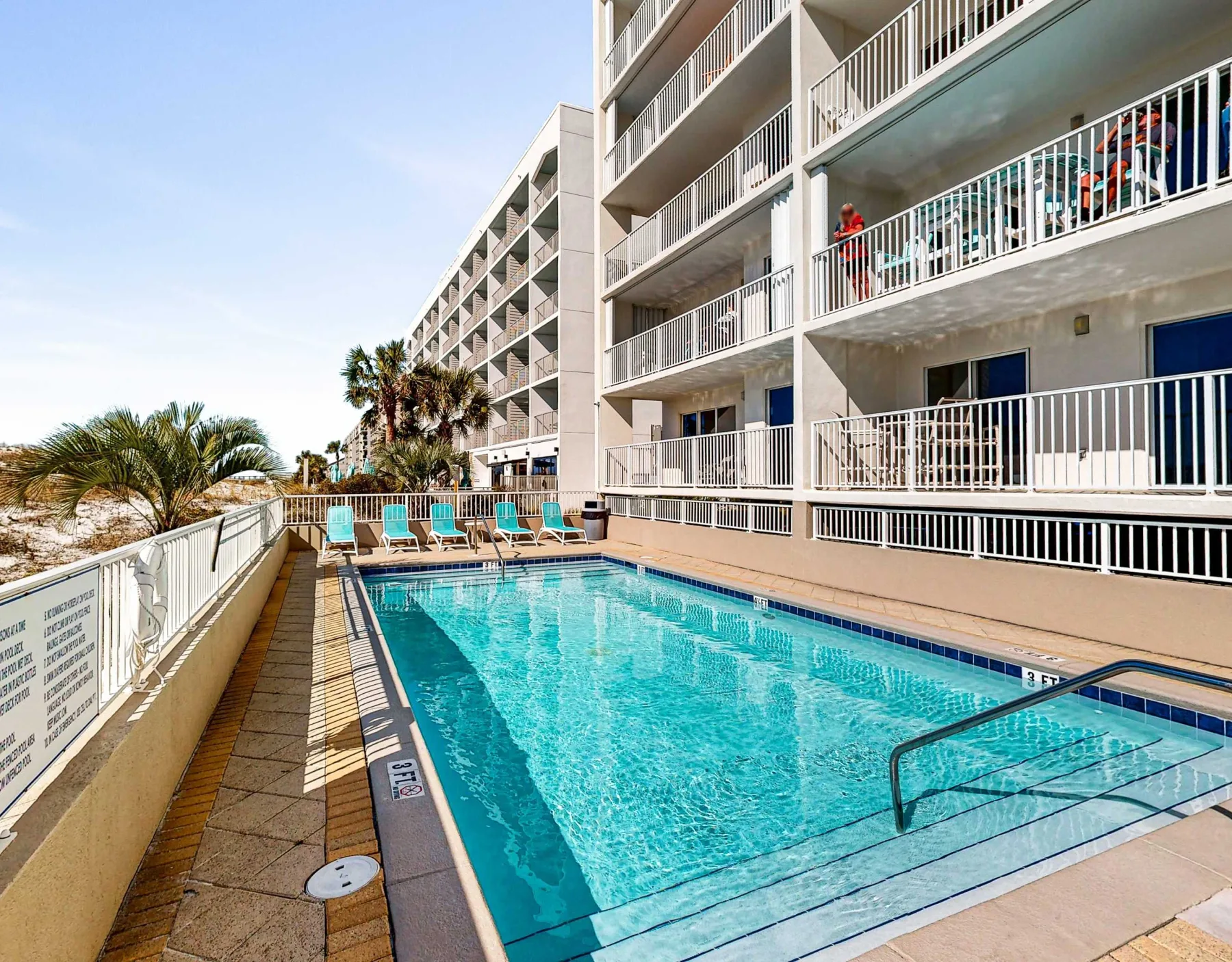 Zona común: Una piscina al aire libre junto a un edificio de varios pisos.