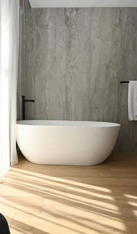 Espacio representativo del hotel: Un baño con una bañera exenta y luz solar sobre el suelo.