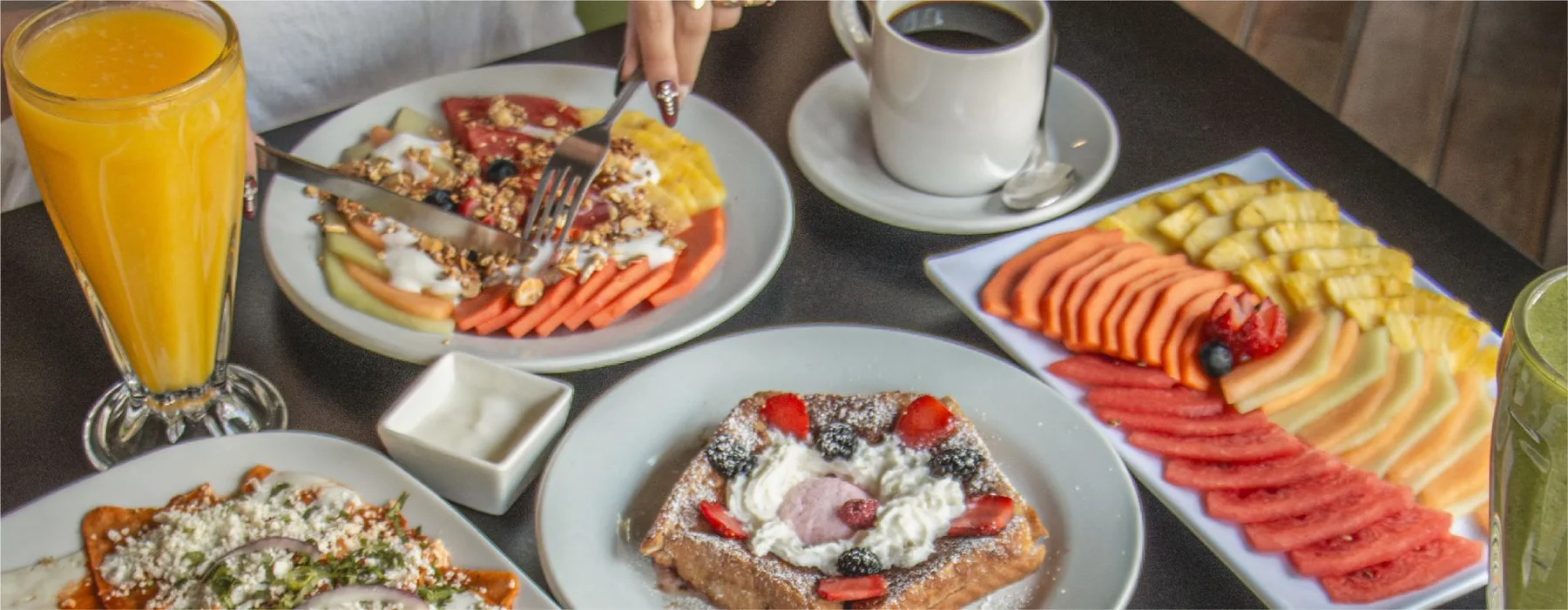 Representative hotel space: A breakfast spread with fruit, pastries, and drinks on a table.