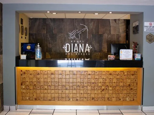 Representative hotel space: Hotel reception desk with a decorative wooden front and signage behind it.