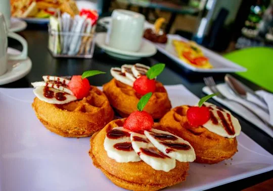 Representative hotel space: A plate of pastries topped with cream, red fruit, and mint leaves.