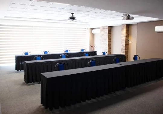 Representative hotel space: A meeting room with rows of tables covered in black cloth.