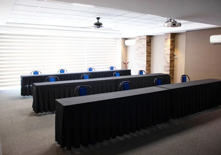 Representative hotel space: A conference room with rows of black-draped tables and blue chairs.