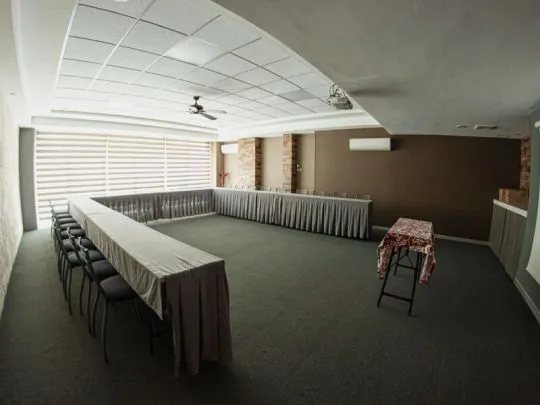 Representative hotel space: A meeting room with long tables arranged in a U shape.