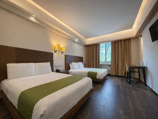 Representative hotel space: A hotel bedroom with two beds, a window, and a small desk.