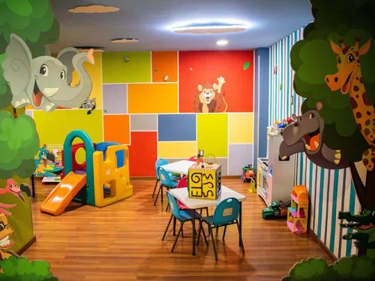 Representative hotel space: A colorful indoor playroom with small tables and chairs.