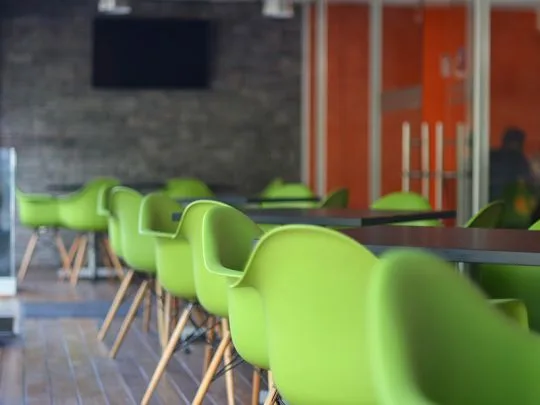 Representative hotel space: A dining area with bright green seating and dark tables.