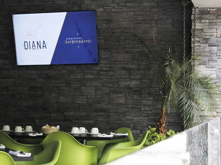 Representative hotel space: A hotel dining area with bright green seating and a wall-mounted display.