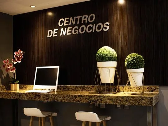 Representative hotel space: A business center reception counter displays a sign and potted plants.