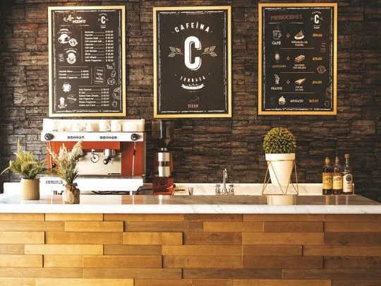 Representative hotel space: A café counter with an espresso machine and menu boards on the wall.