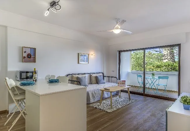 Una luminosa sala-comedor de concepto abierto, con asientos y una mesa junto a la ventana.
