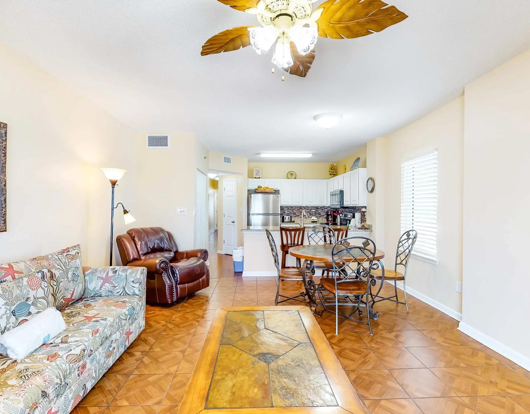 A living and dining area opens onto a kitchen, with seating and a dining table.