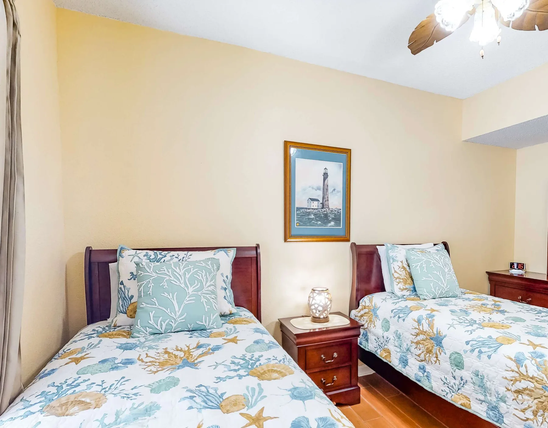 A bedroom with two beds covered in blue and yellow floral bedding.