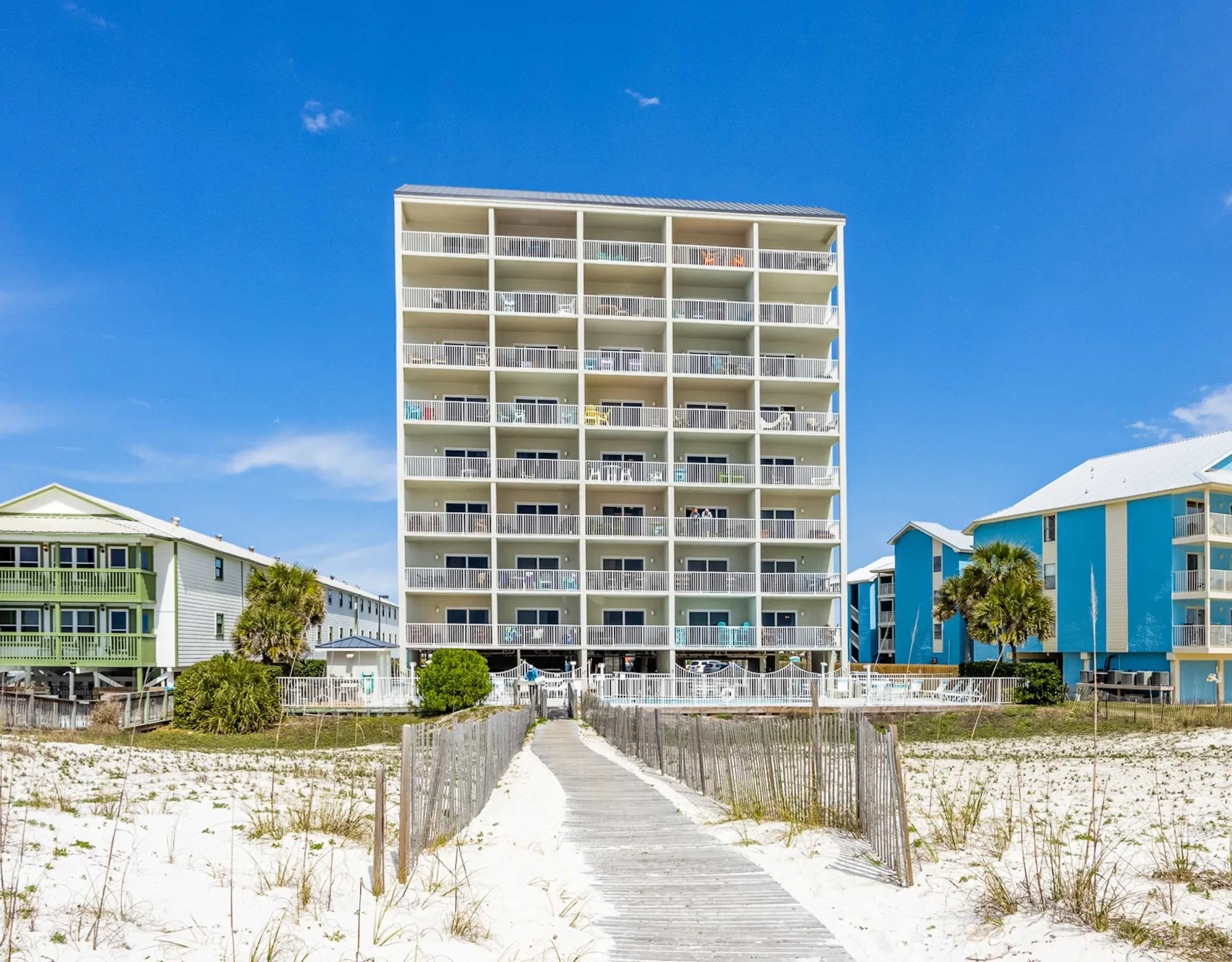 Shared amenity: A boardwalk crosses the sandy beach toward a multi-story building.
