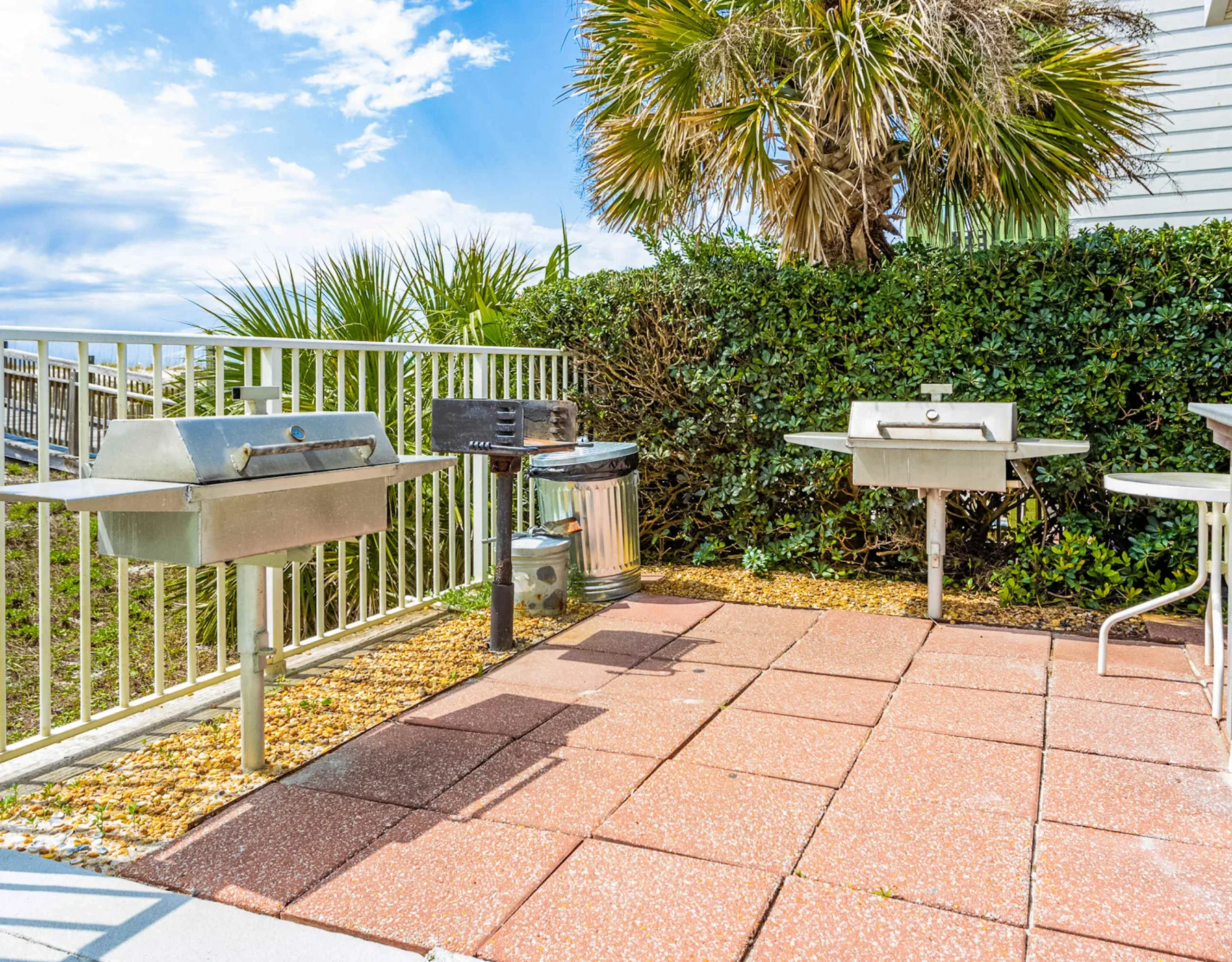 Shared amenity: An outdoor grilling area with barbecue grills beside a paved patio.