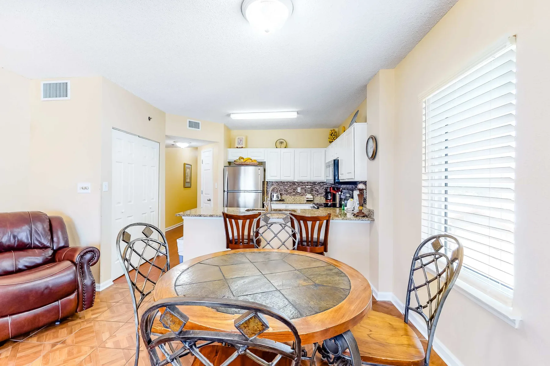 A dining area with a round table beside an open kitchen.