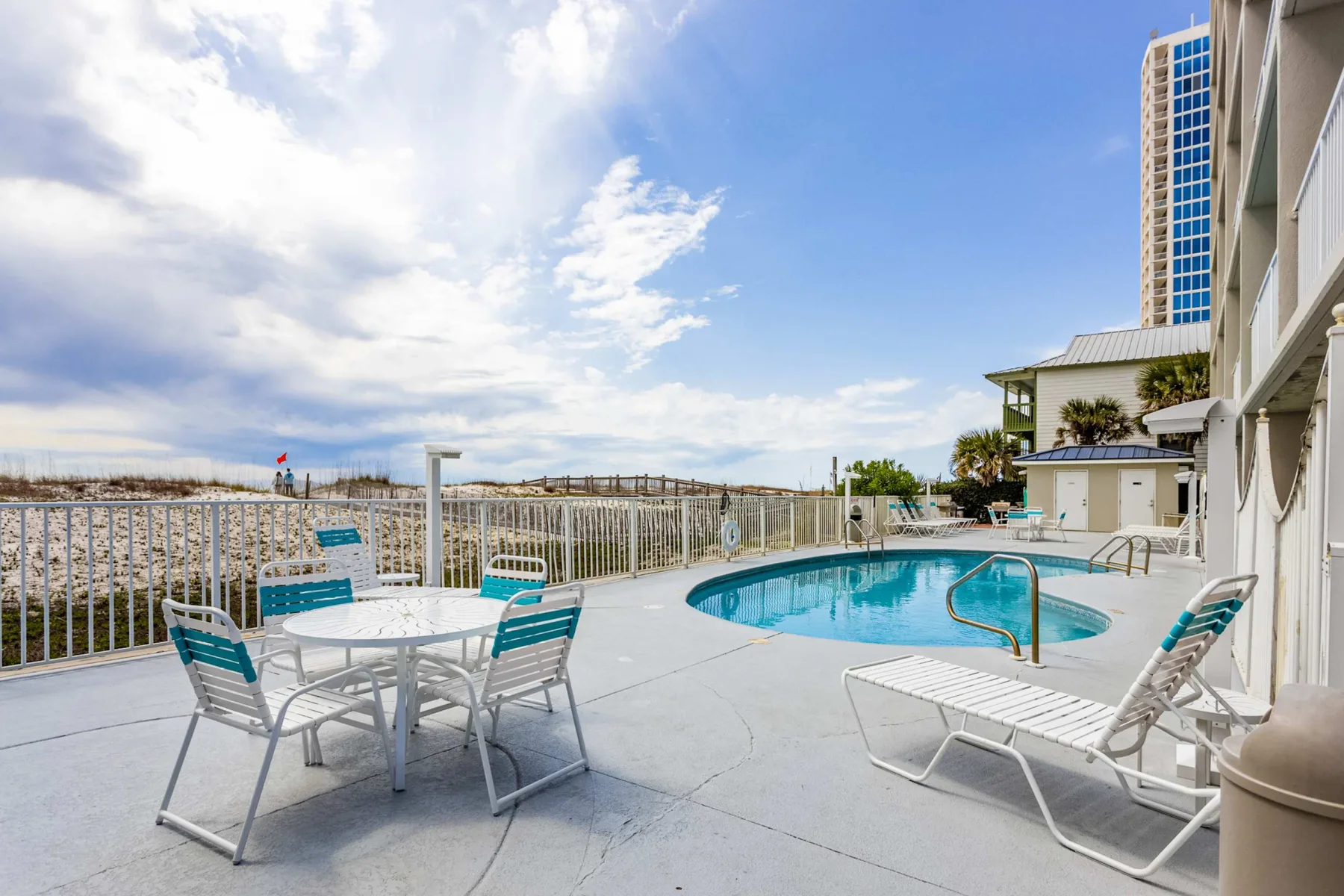 Shared amenity: An outdoor pool with lounge chairs and a table on a sunny terrace.