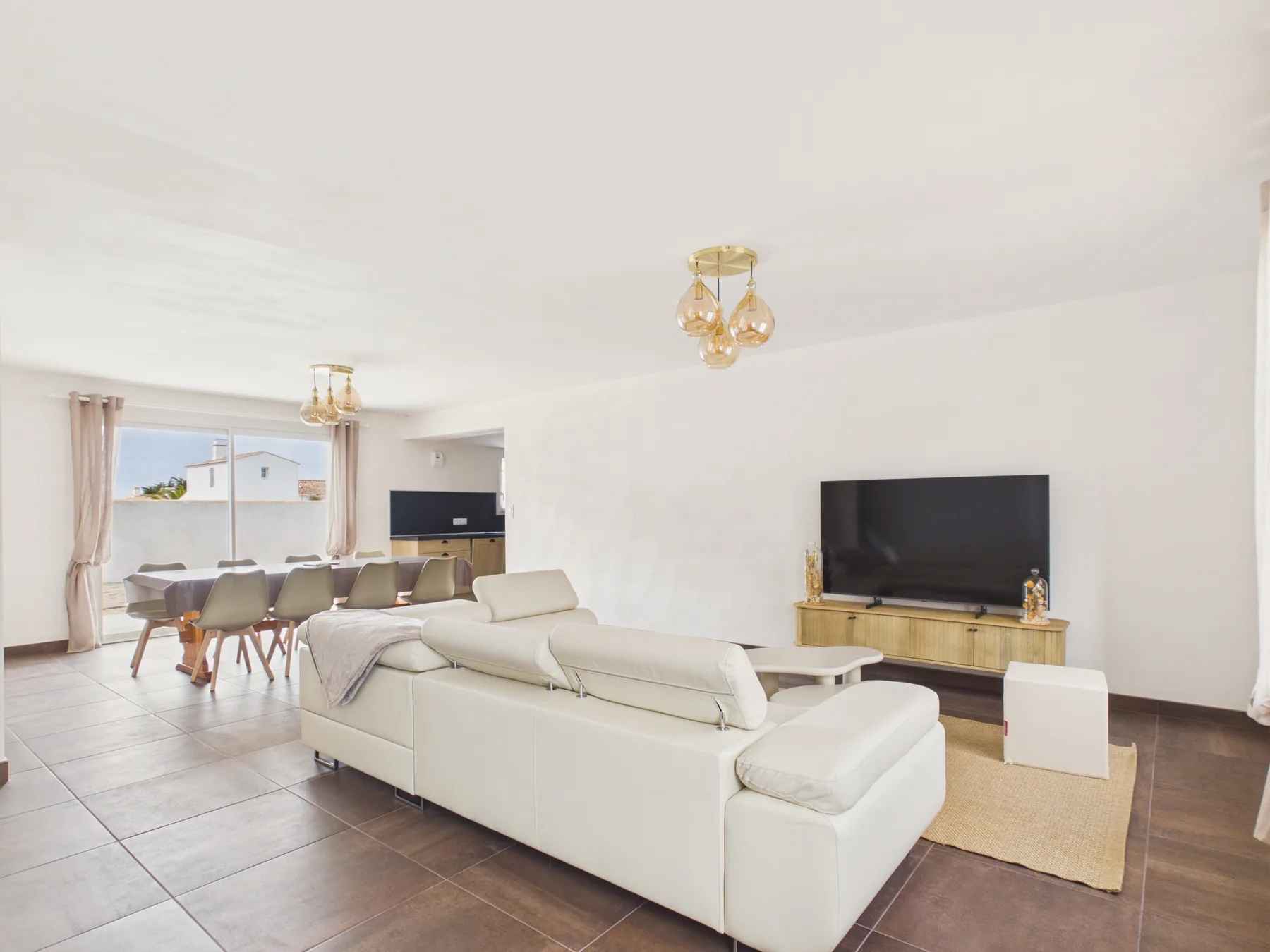 A bright living room with a seating area and television.