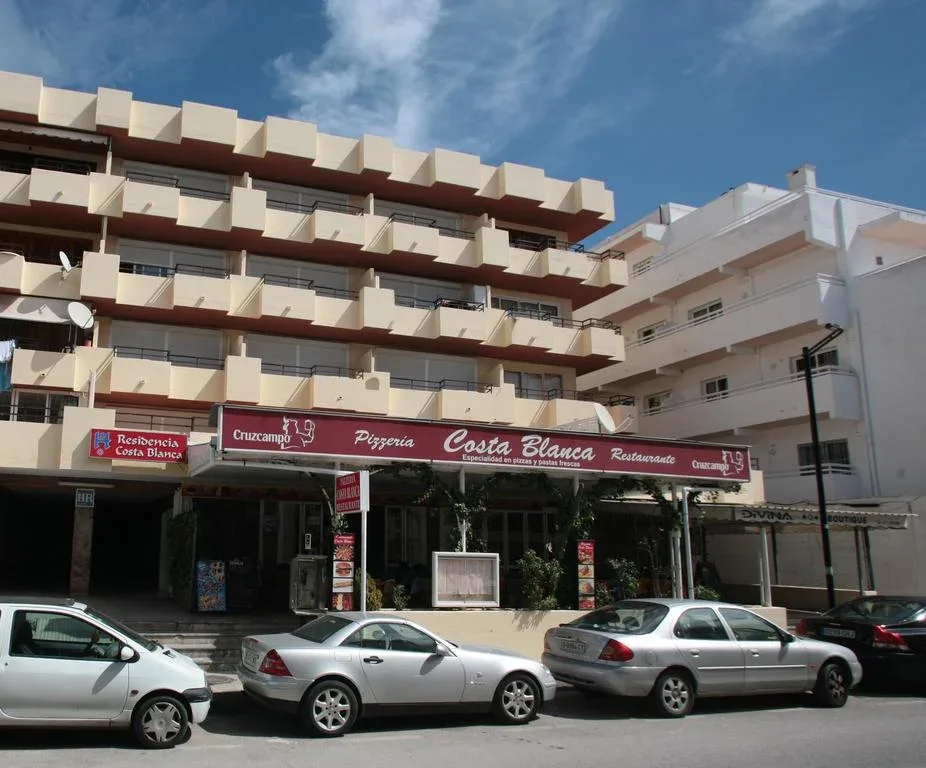 Espacio representativo del hotel: Un edificio hotelero de varios pisos con balcones se alza sobre locales a nivel de calle.