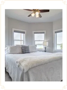 Representative hotel space: A bedroom with a bed beneath three windows.