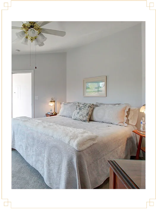 Representative hotel space: A bedroom with a large bed, bedside tables, and a ceiling fan.