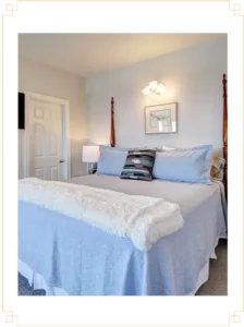 Representative hotel space: A bedroom with a neatly made bed and a bedside lamp.