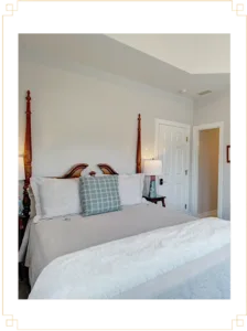 Representative hotel space: A bedroom with a neatly made bed and a white door.