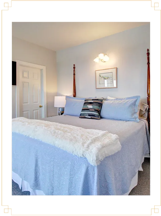 Representative hotel space: A bedroom with a neatly made bed and framed artwork above it.