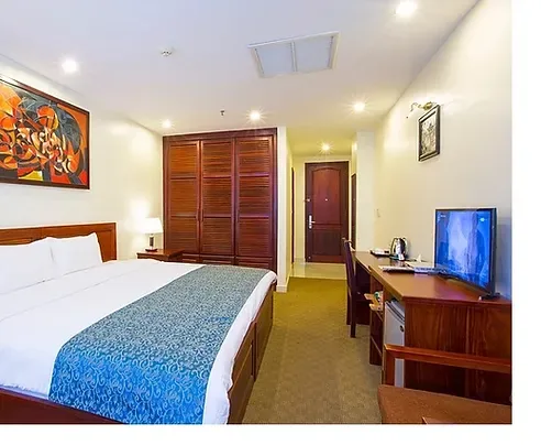 Representative hotel space: A hotel bedroom with a bed, wooden wardrobe, and television.