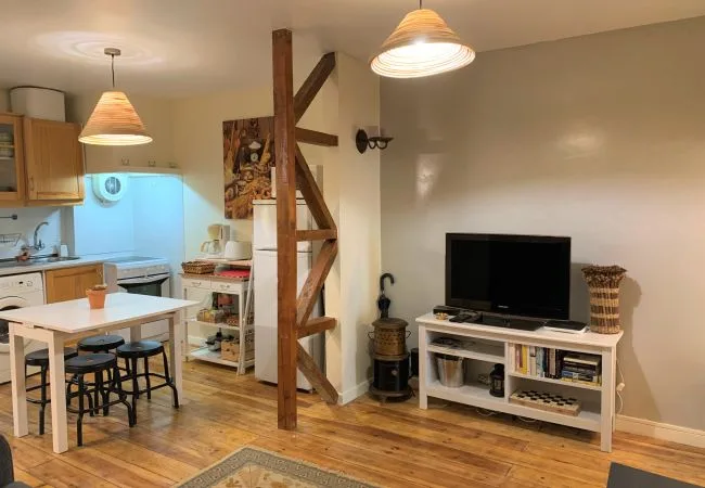 Una cocina compacta y comedor se abren a una sala de estar con televisión.