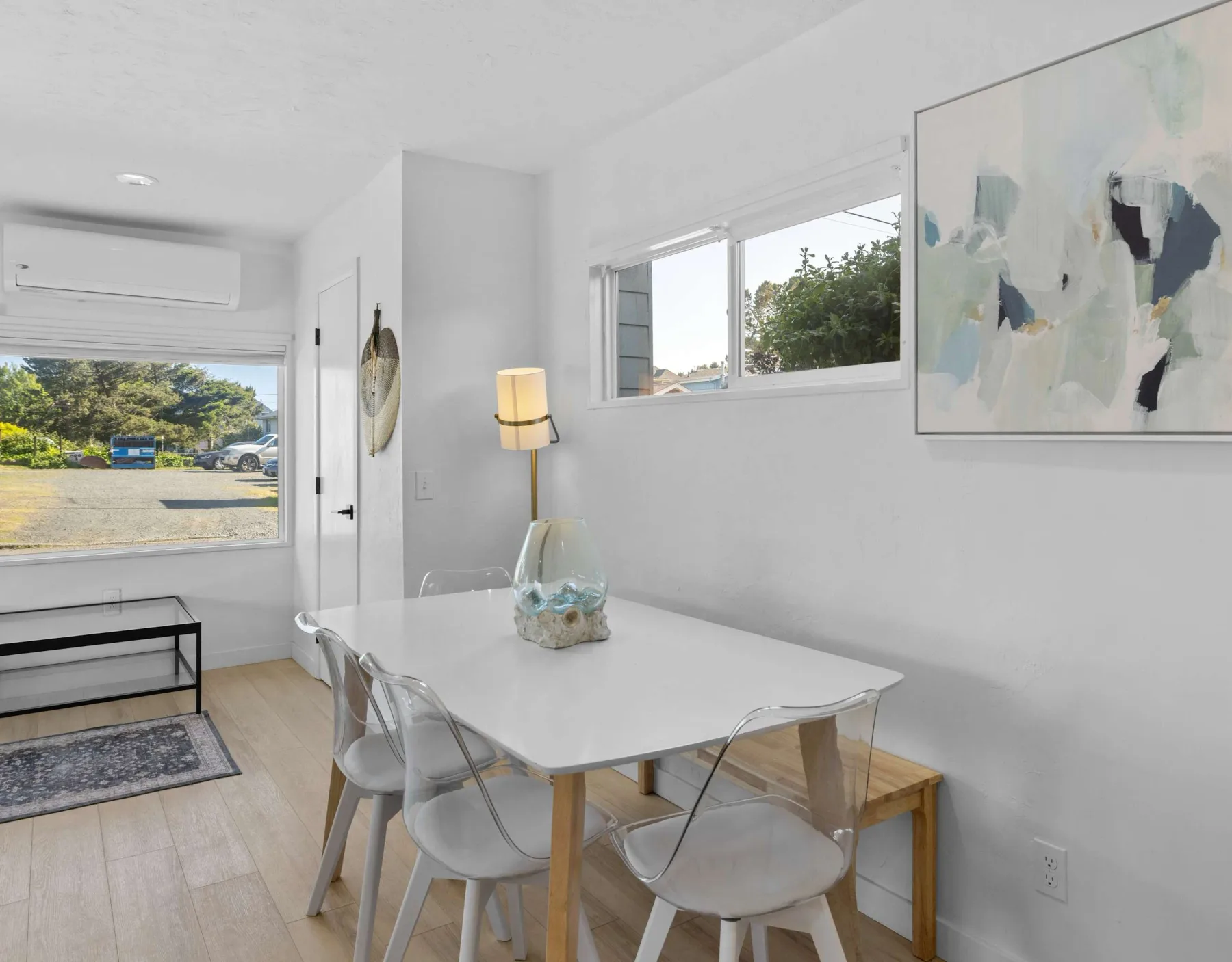 A bright dining area with a white table and large windows.