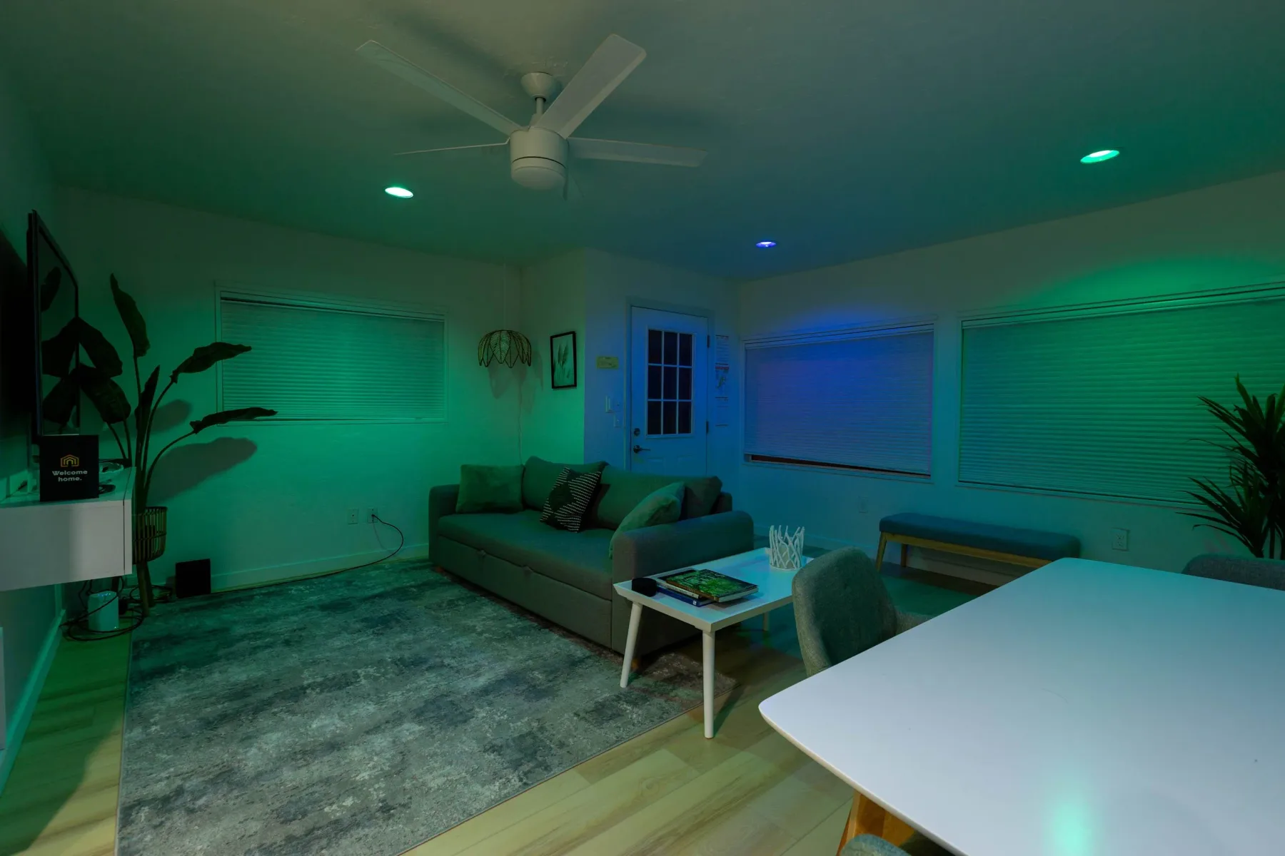 A living room with seating, a coffee table, and large windows.