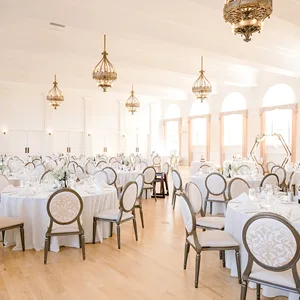 Espacio representativo del hotel: Un salón de banquetes luminoso está dispuesto con mesas redondas y lámparas colgantes decorativas.