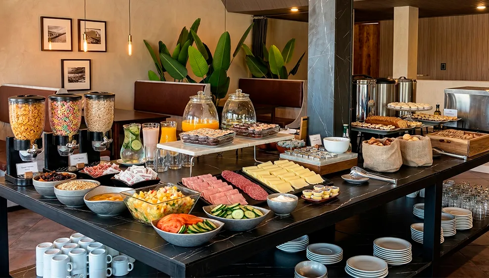 Representative hotel space: A hotel breakfast buffet displays cereal, fruit, pastries, and drinks on a counter.