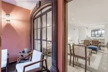 Un comedor con mesa y sillas junto a una puerta alta con paneles de vidrio.