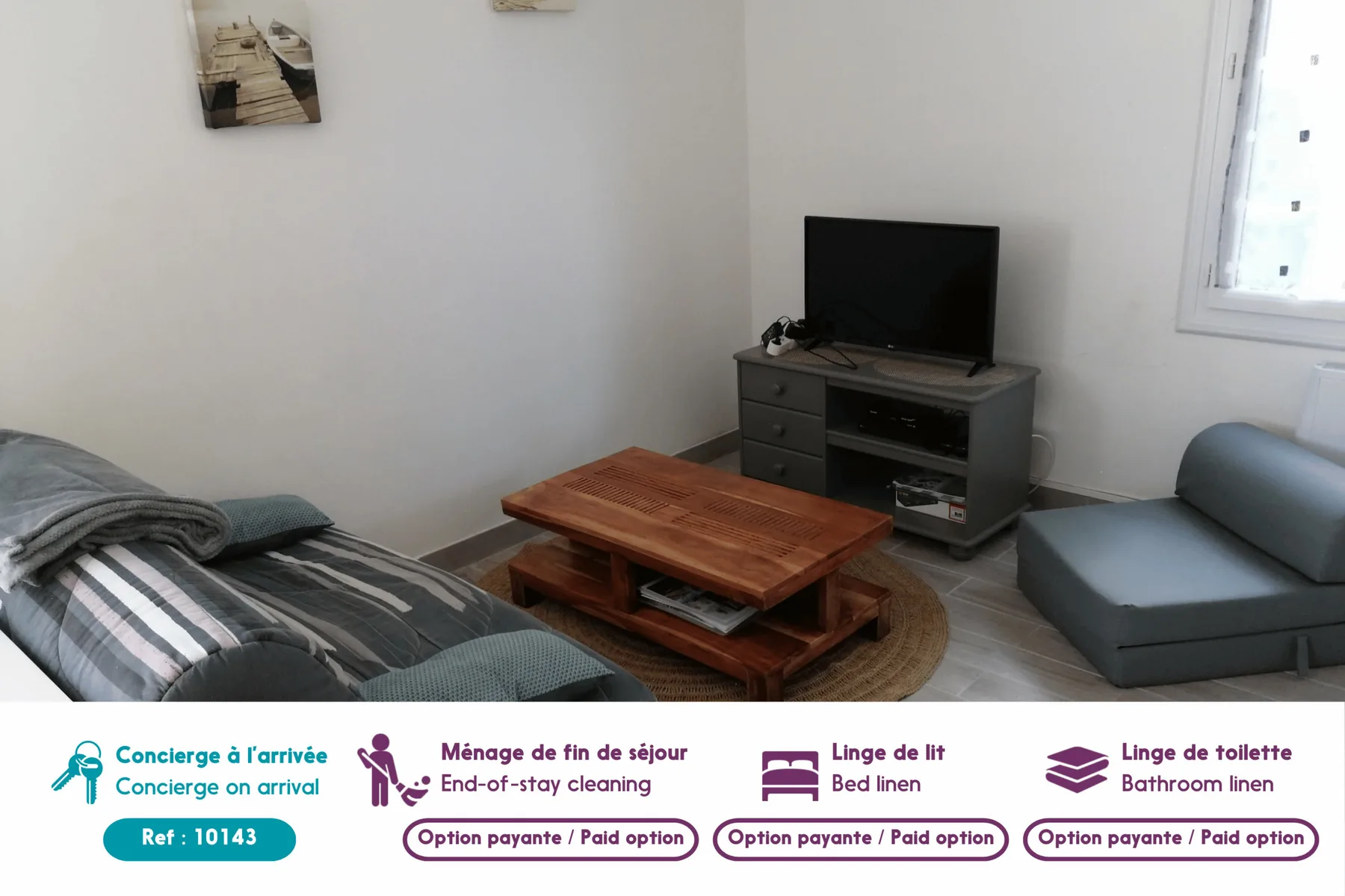 A bedroom and sitting area with a bed, television, and wooden coffee table.