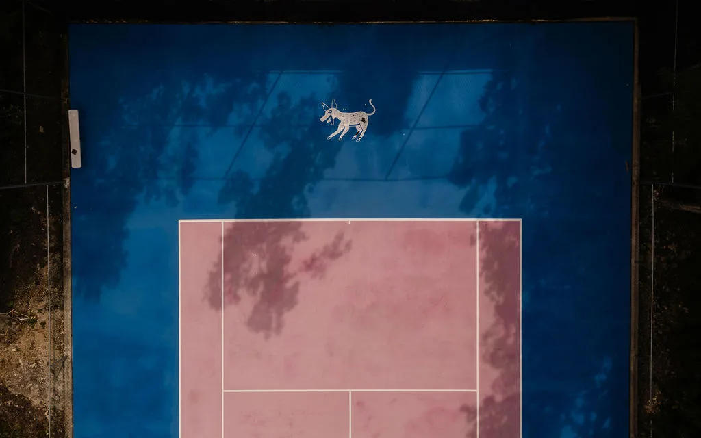 Una cancha deportiva azul con una zona de juego rosa vista desde arriba.